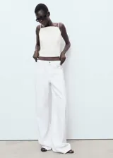 Jeans de tiro bajo y diseño wide leg color blanco, con cierre de botón y cremallera, trabillas para cinto y clásico diseño de cinco bolsillos.