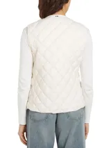 Chaleco acolchado color crema con relleno de plumón, cierre con botones a presión y logo bordado en el pecho.