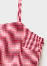Top con tirantes finos, estampado de cuadros vichy rojos y blancos, bajo abullonado con volantes y cierre lateral con cremallera. Diseño entallado.