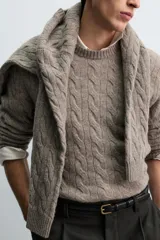 Jersey de punto con diseño de trenzas verticales, cuello redondo y manga larga. Presenta un ajuste regular y acabados en rib en cuello, puños y ruedo.
