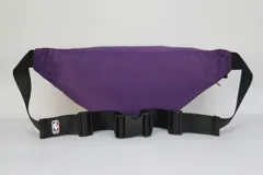 Riñonera de nylon con diseño bicolor en amarillo y violeta, con el logo oficial de Los Angeles Lakers estampado en el frente. Cuenta con cierre principal y correa regulable.