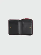Billetera compacta de cuero negro con detalles en rojo, cierre de cremallera y múltiples ranuras para tarjetas.