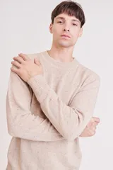 Sweater de punto con cuello redondo, diseño jaspeado en tono beige y puños y ruedo acanalados.