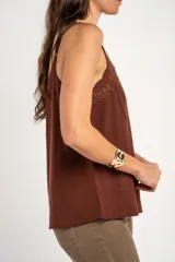 Musculosa blanca de viscosa con tirantes finos, escote en V y detalle de bordado floral con recortes en el borde superior.