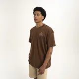 Remera marrón con estampado pequeño en el pecho que dice "We all grow" con una flor.