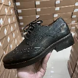 Zapatos Oxford de cuero negro con detalles de perforaciones y cordones.