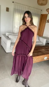 Vestido largo color bordó con escote halter y detalles de volados diagonales.