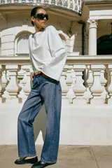 Jeans de tiro alto y corte recto de pernera larga, con diseño clásico de cinco bolsillos y costuras en contraste. Cierre frontal con cremallera y botón metálico.