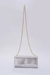 Cartera tipo sobre color beige con textura granulada y correa de cadena dorada.