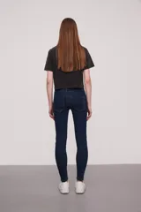 Pantalón jean de corte skinny y tiro medio, con diseño clásico de cinco bolsillos y costuras reforzadas.