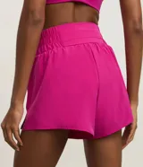 Bermuda deportiva tipo runner color fucsia, con cintura alta elástica y bombacha interna incorporada.