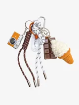 Llavero con dijes colgantes: cámara digital naranja, barra de chocolate marrón, cono de helado tejido a crochet color crema y cordones trenzados.