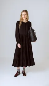 Vestido midi negro con corte en la cintura y falda amplia con volados.