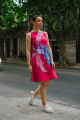Vestido corto magenta con estampado floral en tonos rosados y celestes, sin mangas y corte evasé.