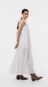 Vestido largo de lino color marrón, de silueta amplia y caída liviana, con escote cuadrado, frunces elastizados en el pecho y breteles anchos con detalles de volados.