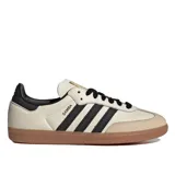 Championes Adidas Samba Og color beige con detalles en negro y suela de goma marrón.