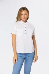 Camisa de lino de manga corta con cuello camisero, cierre frontal de medio botón con botones metálicos personalizados y dos bolsillos en el pecho.