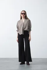 Pantalón wide leg negro de algodón con elastano, de tiro alto y caída recta. Presenta pespuntes a contratono.