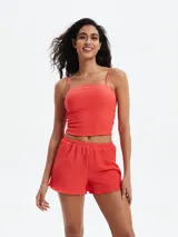 Shorts de mujer color rojo, con textura fruncida o smock en toda la prenda y borde inferior ondulado.