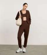 Campera deportiva con capucha ajustable, cierre frontal por cremallera, mangas largas con sisa raglán y puños ajustados. Presenta bolsillo tipo canguro y cordones con lettering estampado.