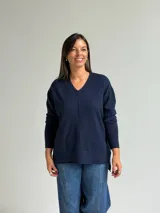 Sweater de punto en color azul marino, con escote en V, manga larga con puños acanalados y costura central vertical en el frente.
