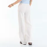 Pantalón de lino blanco de corte ancho, con cintura elástica ajustable mediante cordón y bolsillos laterales.