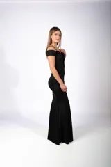 Vestido largo de fiesta color negro, con escote hombros descubiertos, tirantes finos y detalle de apliques brillantes en el escote. Presenta un corte ajustado al cuerpo con una abertura lateral profunda en la falda.