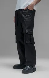 Pantalón cargo de corte oversize y silueta estructurada, confeccionado en microfibra pesada con leve elasticidad. Presenta cintura elástica con cordón de ajuste externo, cierre frontal con botón metálico, bolsillos laterales y bolsillos cargo de gran tamaño con tapa y broches a presión.
