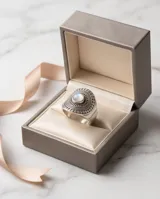 Anillo de plata 925 con diseño ovalado labrado y piedra de la luna central. Presenta detalles de relieve y texturas circulares en toda la superficie.