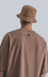 Remera de manga corta, corte crop y calce oversize, color marrón claro (cañamo). Presenta cuello redondo rib al tono y doble costura.