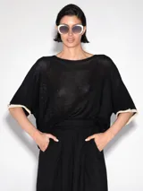 Sweater negro de tejido de punto calado, con mangas cortas amplias y detalle de lurex en los bordes color crudo.