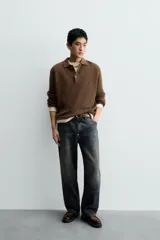 Mocasín de cuero marrón oscuro con antifaz en tono camel. Presenta horma redonda y suela track gruesa de goma negra.