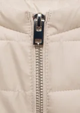 Campera acolchada de cuello redondo y manga larga con puños elásticos. Presenta cierre frontal de cremallera y dos bolsillos laterales con cierre.