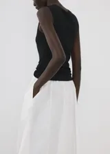 Falda midi evasé de color blanco, confeccionada en tejido de algodón con tiro medio y cintura elástica.