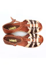 Sandalia tipo arañita Vanzetti con diseño de tiras cruzadas en cuero liso marrón, cuero crema y cuero con textura animal print moteada. Cuenta con cierre de hebilla lateral y suela plana flexible.