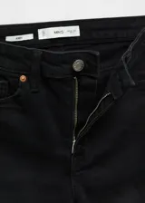 Pantalón de jean estilo skinny, de tiro alto, color negro, con cierre de cremallera y botón, y diseño de cinco bolsillos.