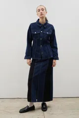 Chaqueta de denim de algodón con corte entallado en la cintura, cuello clásico, cierre frontal con botones metálicos y dos bolsillos con solapa en el pecho.