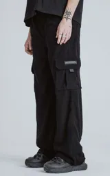 Pantalon cargo de corderoy negro con corte regular, cintura elástica y seis bolsillos, incluyendo dos bolsillos laterales con solapa.