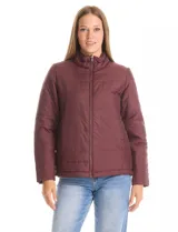 Campera 3 en 1 de color beige, con sistema de capas desmontables. La capa exterior es de tejido técnico resistente al viento y lluvia ligera, con capucha fija, cierre frontal con solapa, bolsillos de parche y ajuste elástico interno en la cintura. Incluye una campera interior capitoneada ultraliviana que puede usarse de forma independiente.
