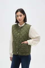 Chaleco acolchado de color negro con diseño de rombos, cierre frontal con botones metálicos a presión y dos bolsillos delanteros aplicados.