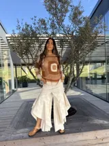 Pantalón de jean azul oscuro con diseño fluido y volados en las piernas.