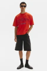 Remera de algodón en color rojo, con cuello redondo acanalado, mangas cortas y hombros caídos. Presenta un estampado frontal con la leyenda "SOHO NYC ATH DEPT".