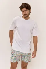 Short de baño celeste con estampa tropical de flores, cintura con cordón ajustable y detalle de etiqueta textil en el lateral.