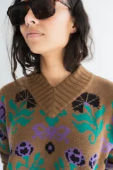 Buzo tejido de algodón negro con diseño jacquard de flores multicolor, cuello en V y mangas largas.