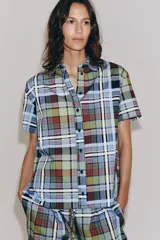 Camisa de manga corta de algodón, con cuello de solapa, cierre frontal de botones y bajo recto, con estampado de cuadros multicolores.
