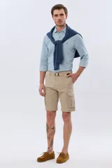 Bermuda cargo color azul marino, de gabardina con bolsillos laterales con solapa en las piernas y presillas para cinturón. Incluye cinturón de lona trenzada oscura con detalles en cuero sintético y hebilla metálica.