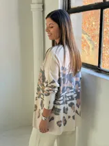 Sweater de punto con cuello en V, diseño holgado y estampado animal print con detalles en dorado.