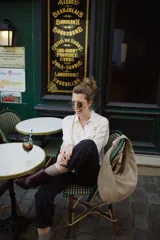 Bolso tipo hobo de cuero marrón con textura de piel de cocodrilo, asa anudada y cierre superior abierto.