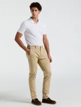 Pantalón chino color beige, con bolsillos delanteros diagonales, cierre y botón en la cintura. Logo bordado a tono.