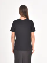 Remera de algodón color negro, de corte clásico con cuello redondo y mangas cortas. Presenta la palabra 'UNBOTHERED' estampada en letras blancas en el centro del pecho.